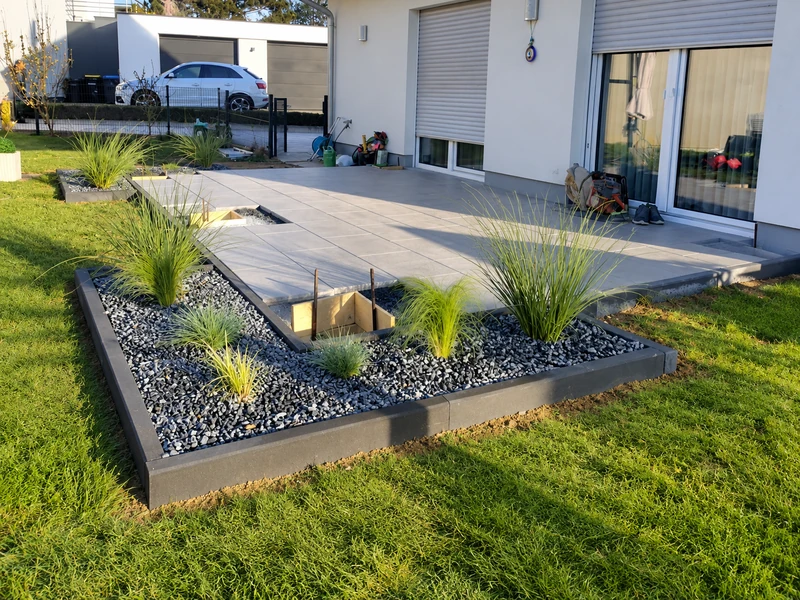 Terrasse mit Plattenbelag und angrenzender Bepflanzung