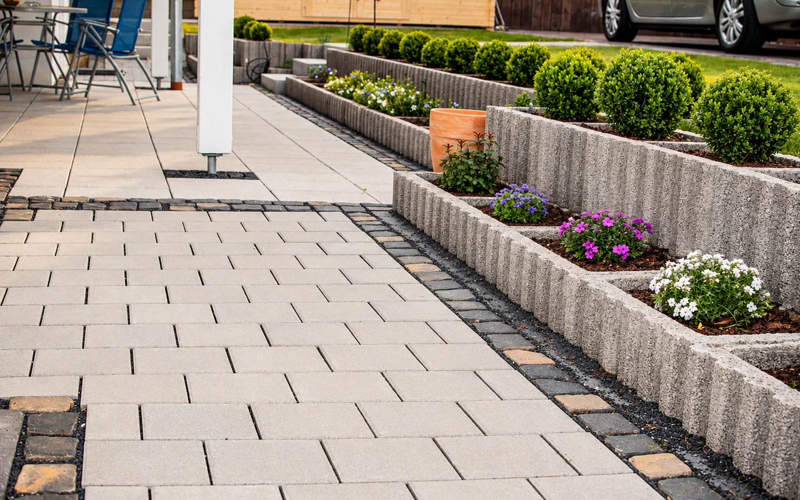 Terrassenplatten mit eingefassten Pflanzbeeten